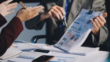 Bir grup menajer iş saatinden sonra akşam saatlerinde takım toplantısı yapıyor. Meslektaşlar Yıllık Finansal ve Pazarlama Raporlarını Tartışıyor. Yaratıcı Ofis 'te takım çalışması. Eller Üzerinde Kapat.