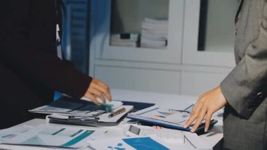 Bir grup menajer iş saatinden sonra akşam saatlerinde takım toplantısı yapıyor. Meslektaşlar Yıllık Finansal ve Pazarlama Raporlarını Tartışıyor. Yaratıcı Ofis 'te takım çalışması. Eller Üzerinde Kapat.