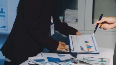 Bir grup menajer iş saatinden sonra akşam saatlerinde takım toplantısı yapıyor. Meslektaşlar Yıllık Finansal ve Pazarlama Raporlarını Tartışıyor. Yaratıcı Ofis 'te takım çalışması. Eller Üzerinde Kapat.