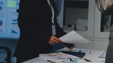 Bir grup menajer iş saatinden sonra akşam saatlerinde takım toplantısı yapıyor. Meslektaşlar Yıllık Finansal ve Pazarlama Raporlarını Tartışıyor. Yaratıcı Ofis 'te takım çalışması. Eller Üzerinde Kapat.