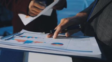 Bir grup menajer iş saatinden sonra akşam saatlerinde takım toplantısı yapıyor. Meslektaşlar Yıllık Finansal ve Pazarlama Raporlarını Tartışıyor. Yaratıcı Ofis 'te takım çalışması. Eller Üzerinde Kapat.