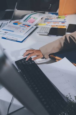 Tablet, akıllı telefon ve dizüstü bilgisayarlı iş belgeleri ve veri tartışan iki iş arkadaşı