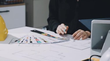 Çalışma ve tablet hakkında konuşan iki meslektaş, ofisteki inşaat sahasında mimari projeyle ilgili bilgisayarı açtılar.