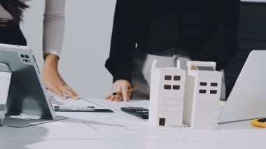 Çalışma ve tablet hakkında konuşan iki meslektaş, ofisteki inşaat sahasında mimari projeyle ilgili bilgisayarı açtılar.