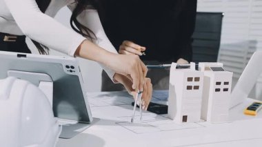 Çalışma ve tablet hakkında konuşan iki meslektaş, ofisteki inşaat sahasında mimari projeyle ilgili bilgisayarı açtılar.