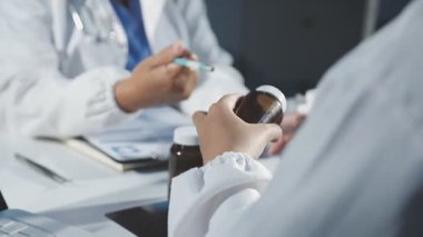 Doktor hastanede otururken tablet bilgisayar kullanıyor.