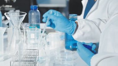 Kadın bilim adamı elinde test tüpleri tutuyor.