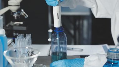 Bilim adamı laboratuarda test tüpü tutuyor..