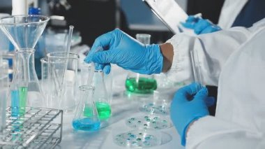 Laboratuvarda elinde matarayla duran bilim adamlarının yakın çekimi.