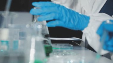 Laboratuvarda deney tüpünü tutan bilim adamının elini kapatın.