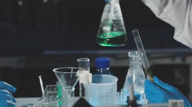 Laboratuvarda test tüpünü sıvı ile tutan bilim adamının yakın çekimi..