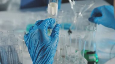 Laboratuvardaki bilim adamı test tüpleri tutuyor.