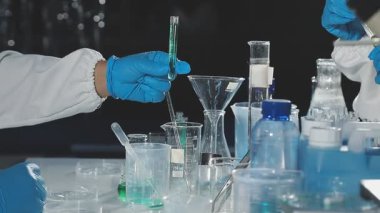 Laboratuvarda deney tüpüyle çalışan bir laboratuvar asistanı..