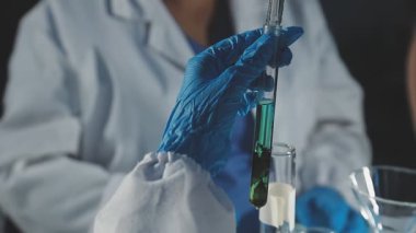 Bilim adamı elinde matara tutuyor.