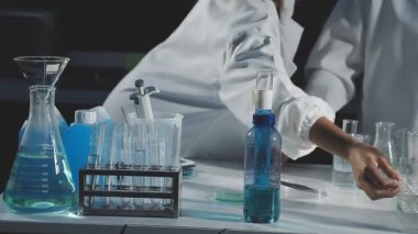 Kimyasal laboratuvar ekipmanlarıyla çalışan bir bilim adamının yakın plan çekimi.