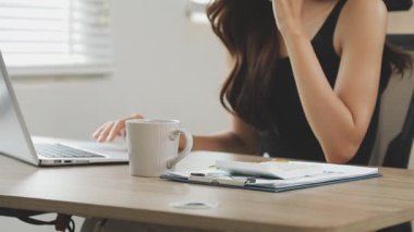 İş kadını ofisteki masada dizüstü bilgisayar kullanıyor.