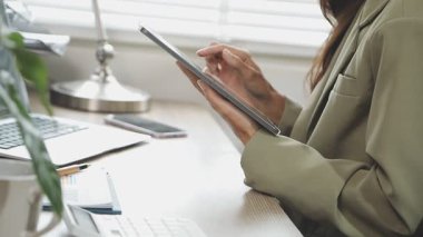 Ofiste dijital tabletle çalışan iş kadını.