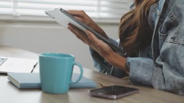 Dizüstü bilgisayarını kullanan genç bir kadının kırpılmış görüntüsü..