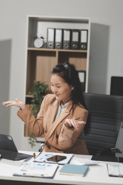 Asyalı iş kadını dizüstü bilgisayar kullanıyor ve ofiste hesap makinesi ile çalışıyor, mali raporu, iş planı yatırımını, mali analiz konseptini analiz etmeyi planlıyor..