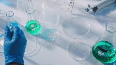 Laboratuvar asistanının deney tüpünü pipetle tuttuğu yakın plan. bilimsel araştırma, bilim, teknoloji, tıp, kimya ve araştırma kavramı.