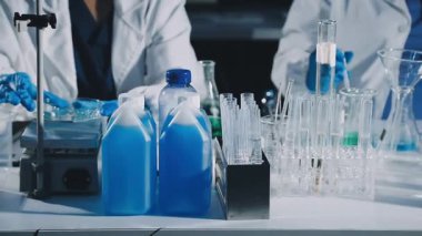 Laboratuvarda kimyasal ekipmanlarla çalışan bilim adamlarına yakın çekim