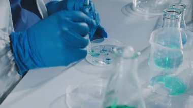 Laboratuvarda kimyasal çözeltiyle çalışan bilim adamı.