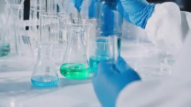 Laboratuvarda mavi sıvıyla laboratuvar asistanı.