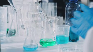 Laboratuvarda deney tüpüyle çalışan bir bilim adamının yakın görüntüsü.