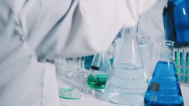 Yakın plan. Üniformalı bir laboratuvar çalışanı deney yapıyor.