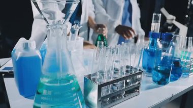 Laboratuvarda mavi sıvıyla çalışan bilim adamı