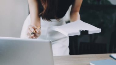 Ofiste tablet bilgisayar kullanan genç bir kadın..