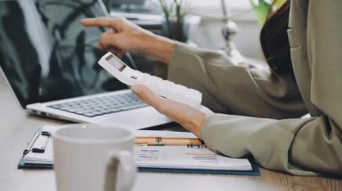 İş kadını modern ofiste çalışmak için akıllı telefon kullanıyor.