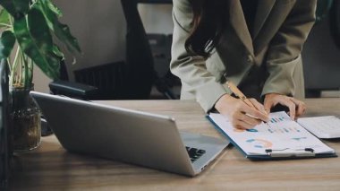 İş kadını ofis masasında dizüstü bilgisayar kullanıyor.