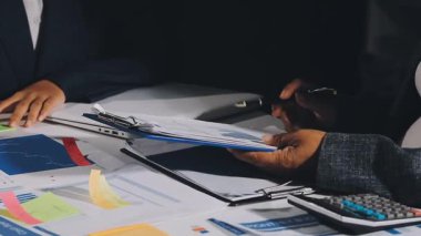 Takım elbiseli ve kravatlı işadamı mali rapor üzerinde çalışıyor