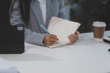 Asyalı iş kadını dizüstü bilgisayar kullanıyor ve ofiste hesap makinesi ile çalışıyor, mali raporu, iş planı yatırımını, mali analiz konseptini analiz etmeyi planlıyor..