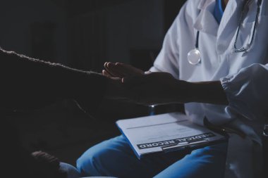 Dişi bir hemşire yaşlı bir kadını cesaretlendirmek ve teselli etmek için el ele tutuşur. Emeklilik yaşındakiler için bakım ve bakım evleri. Bakıcı yaşlı kadınlara tıbbi tavsiyelerde bulunuyor.