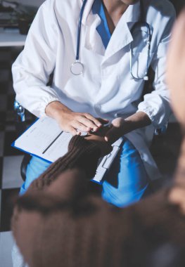 Dişi bir hemşire yaşlı bir kadını cesaretlendirmek ve teselli etmek için el ele tutuşur. Emeklilik yaşındakiler için bakım ve bakım evleri. Bakıcı yaşlı kadınlara tıbbi tavsiyelerde bulunuyor.