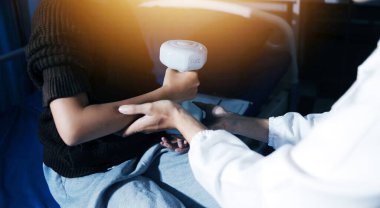 Evde dambıl kullanarak fizyoterapist eğitimi alan yaşlı bir kadın. Terapist, huzurevi egzersizlerinde yaşlı kadına yardım ediyor. Yaşlı bir hasta kollarını uzatmış halterler kullanıyor..