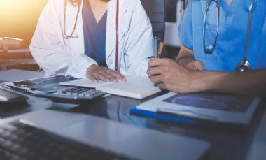 Doktorlar tedavi seçeneklerini tartışmak ve iş arkadaşlarıyla deneyimleri paylaşmak için hastanede toplanıyorlar.