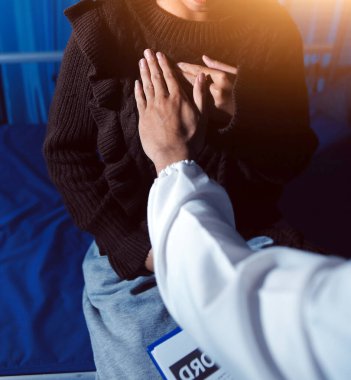 Ev bakımı hemşiresi ve yaşlılar kardiyoloji sağlık hizmetleri. Genç İspanyol kadın doktor hemşirenin yakın çekimleri sırasında steteskop kullanarak olgun beyaz hasta kalp atışlarını kontrol et.