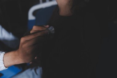 Ev bakımı hemşiresi ve yaşlılar kardiyoloji sağlık hizmetleri. Genç İspanyol kadın doktor hemşirenin yakın çekimleri sırasında steteskop kullanarak olgun beyaz hasta kalp atışlarını kontrol et.