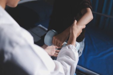 Evde dambıl kullanarak fizyoterapist eğitimi alan yaşlı bir kadın. Terapist, huzurevi egzersizlerinde yaşlı kadına yardım ediyor. Yaşlı bir hasta kollarını uzatmış halterler kullanıyor..