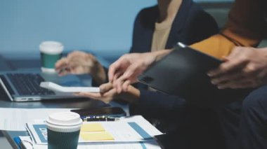 Ofiste belgelerle çalışan genç bir iş kadını..