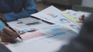 business man pointing on graph with pen at office