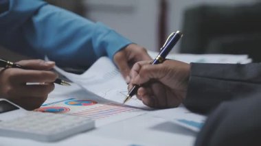 İşadamı masadaki kalemle grafiği analiz ediyor