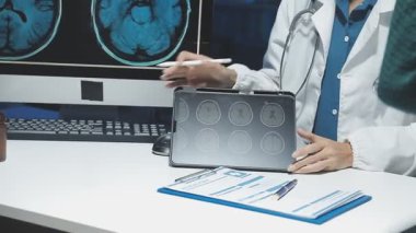 doctor holding x - ray image with patient