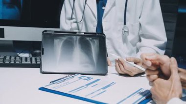 Gastroenterolog klinikteki hastayı inceliyor, insan mide modeline odaklanıyor.