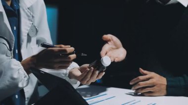 Gastroenterolog klinikteki hastayı inceliyor, insan mide modeline odaklanıyor.