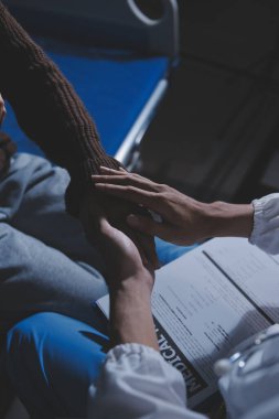 Dişi bir hemşire yaşlı bir kadını cesaretlendirmek ve teselli etmek için el ele tutuşur. Emeklilik yaşındakiler için bakım ve bakım evleri. Bakıcı yaşlı kadınlara tıbbi tavsiyelerde bulunuyor.