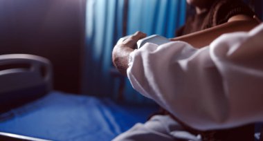 Evde dambıl kullanarak fizyoterapist eğitimi alan yaşlı bir kadın. Terapist, huzurevi egzersizlerinde yaşlı kadına yardım ediyor. Yaşlı bir hasta kollarını uzatmış halterler kullanıyor..